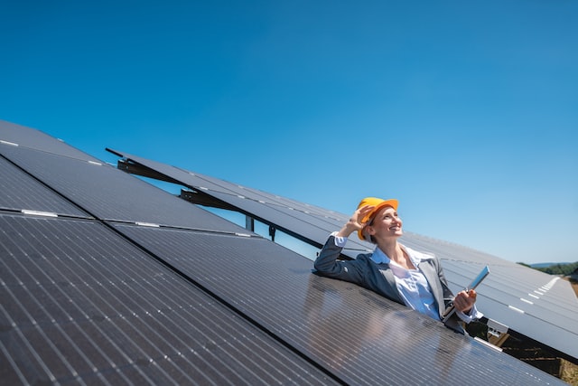 En elektriker står vid en solcellsanläggning.